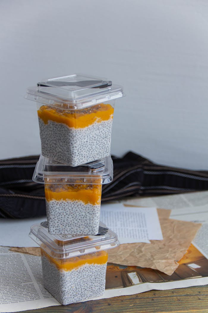 Stacked chia pudding containers with mango topping, perfect for healthy snacking.